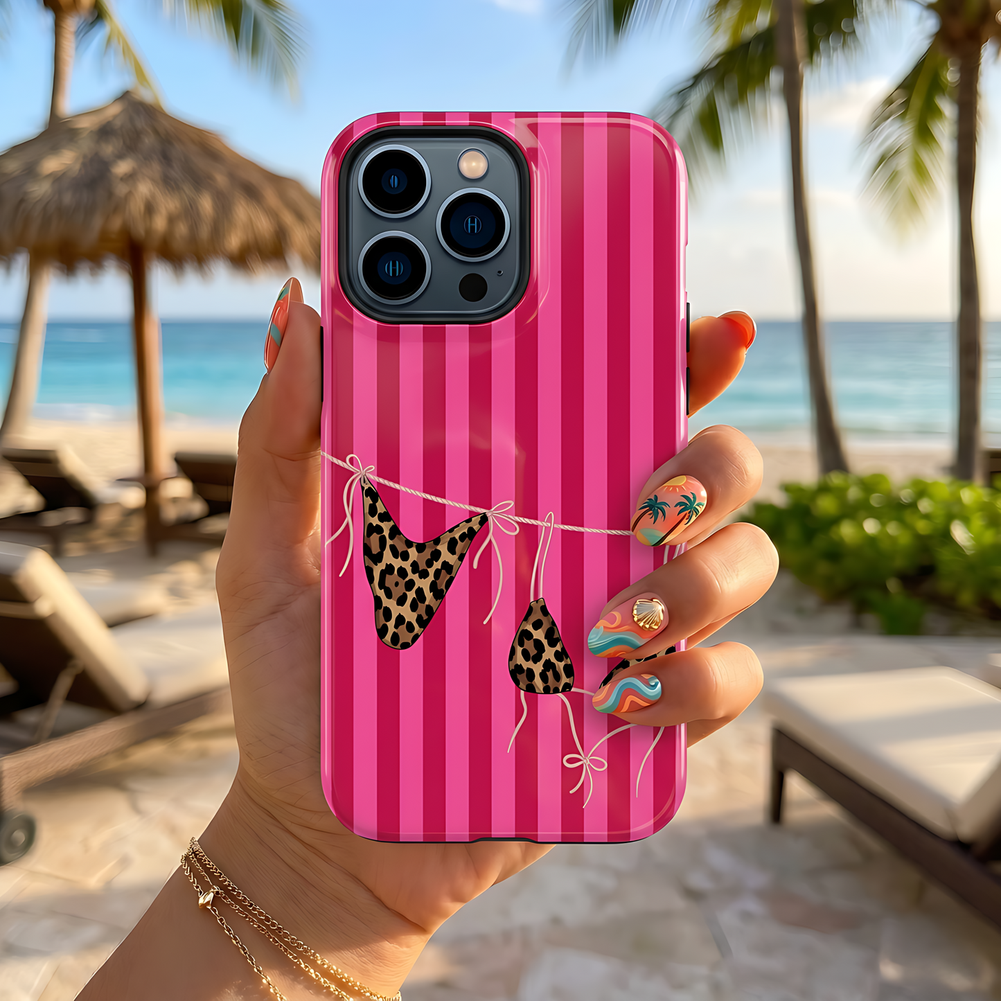 Phone case with leopard print bikini design held by a hand on a beach.