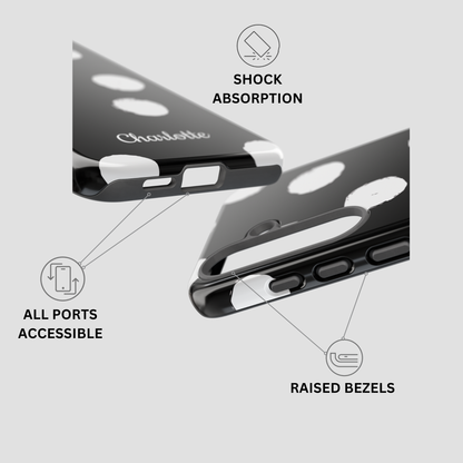 Black phone case with white circular cutouts and raised white bezels, shown from multiple angles with callout icons and text reading 'SHOCK ABSORPTION,' 'ALL PORTS ACCESSIBLE,' and 'RAISED BEZELS.'.