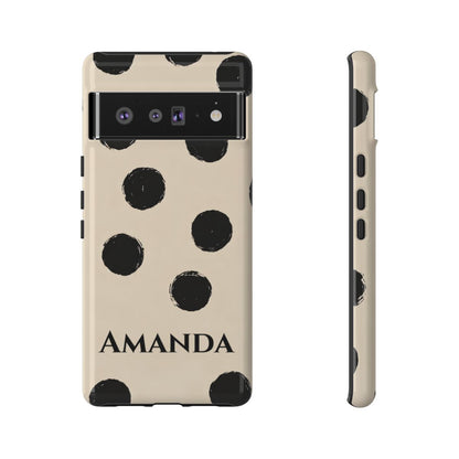 A personalized phone case shown from the back and side views on a white background. The case has a cream-colored base with black polka dots and the name 'AMANDA' printed in black at the bottom.