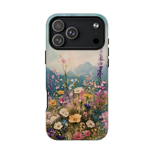 Phone case featuring a vibrant field of pink, yellow, and purple wildflowers with a blue mountain range in the background.